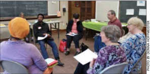 six people sitting on chairs in a circle and talking